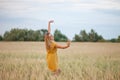 Happy woman enjoying the life in the golden wheat field. She dancing on a field Royalty Free Stock Photo