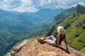 Happy woman enjoying nature on top of mountain cliff