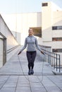 Happy woman exercising with jump-rope outdoors Royalty Free Stock Photo