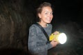 Happy woman explorer holds a flashlight while caving and spelunking underground at Lava Beds National Monument in California Royalty Free Stock Photo