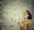 Happy woman exults pumping fists ecstatic celebrates success under a money rain Royalty Free Stock Photo