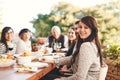 Happy woman, family and food outdoor at patio table for thanksgiving or Christmas celebration wine, alcohol and meal for Royalty Free Stock Photo