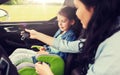 Happy woman fastening child with seat belt in car Royalty Free Stock Photo