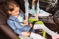 Happy woman fastening child with seat belt in car Royalty Free Stock Photo