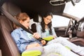 Happy woman fastening child with seat belt in car Royalty Free Stock Photo