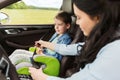 Happy woman fastening child with seat belt in car Royalty Free Stock Photo