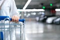 Happy woman female with closeup shopping cart or trolley in car parking of fresh maket for healthy housewife in supermarket store