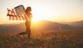 Happy woman with flag of united states enjoying the sunset on na Royalty Free Stock Photo