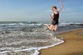 Happy woman flies with with mobile phone on beach Royalty Free Stock Photo