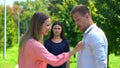 Happy woman flirting with man, jealous brunette friend on background, betrayal Royalty Free Stock Photo