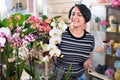 Happy woman florist showing multicolored phalaenopsis flowers