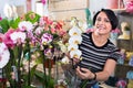 Happy woman florist showing multicolored phalaenopsis flowers