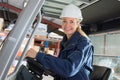 happy woman forklift truck driver in industrial area