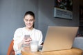 Cheerful female marketer chatting on mobile phone, sitting with notebook in bar Royalty Free Stock Photo