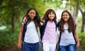 Happy woman, friends and hug walking with backpack in park for unity, teamwork or school together. Group of young people Royalty Free Stock Photo
