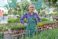 Happy  woman gardener choosing flower pot with anthuriums in garden center Royalty Free Stock Photo