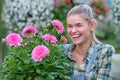 Happy  woman gardener choosing flower pot with anthuriums in garden center Royalty Free Stock Photo