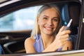 Happy woman getting car key in auto show or salon Royalty Free Stock Photo