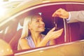 Happy woman getting car key in auto show or salon Royalty Free Stock Photo