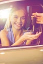 Happy woman getting car key in auto show or salon Royalty Free Stock Photo