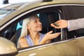 Happy woman getting car key in auto show or salon Royalty Free Stock Photo