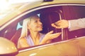 Happy woman getting car key in auto show or salon Royalty Free Stock Photo