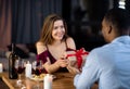 Happy Woman Getting Gift From Her Black Boyfriend On Dinner At Restaurant Royalty Free Stock Photo