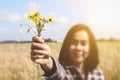 Happy Woman gives yellow Flowers in sunny meadow with blue sky.