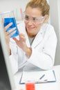 Happy woman in glasses looking at flask liquid Royalty Free Stock Photo