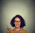 Happy woman in glasses pointing up with her finger