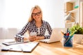 Happy woman in glasses typing sms on smartphone in office Royalty Free Stock Photo