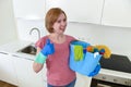 Happy woman in gloves holding cleaning bucket with cloth and household Royalty Free Stock Photo