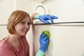 Happy woman in gloves holding cleaning bucket with cloth and household Royalty Free Stock Photo