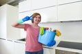 Happy woman in gloves holding cleaning bucket with cloth and household Royalty Free Stock Photo