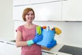 Happy woman in gloves holding cleaning bucket with cloth and household Royalty Free Stock Photo