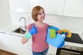 Happy woman in gloves holding cleaning bucket with cloth and household Royalty Free Stock Photo