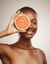 Happy woman, grapefruit and portrait of skincare in studio for vitamin c, vegan cosmetics and glow on brown background