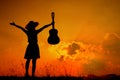 Happy Woman and guitar with sunset silhouette