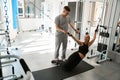 Happy woman in the gym performs muscle stretching exercises