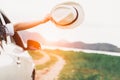 Happy woman hand holding hat outside open window car with meadow and mountain lake background. People lifestyle relaxing as Royalty Free Stock Photo