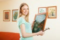 Happy woman hanging the art picture Royalty Free Stock Photo