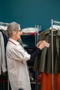 Happy woman hanging price tag on shirt