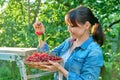 Happy woman with harvest of red ripe cherries in summer garden Royalty Free Stock Photo