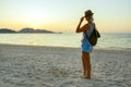 Happy Woman in Hat Enjoying Beautiful Sunset on the Beach. Travel in Asia concept.