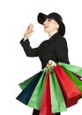 Happy woman in hat with paper bags on white background