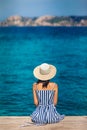 Happy woman in hat relaxing on sea pier in Sardinia island, Italy Royalty Free Stock Photo