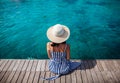 Happy woman in hat relaxing on sea pier in Sardinia island, Italy Royalty Free Stock Photo