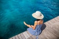 Happy woman in hat relaxing on sea pier in Sardinia island, Italy Royalty Free Stock Photo