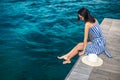 Happy woman in hat relaxing on sea pier in Sardinia island, Italy Royalty Free Stock Photo