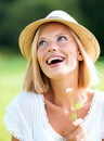 Happy woman, hat and thinking in nature with flower for sunshine, freedom or outdoor vacation. Young female person or Royalty Free Stock Photo